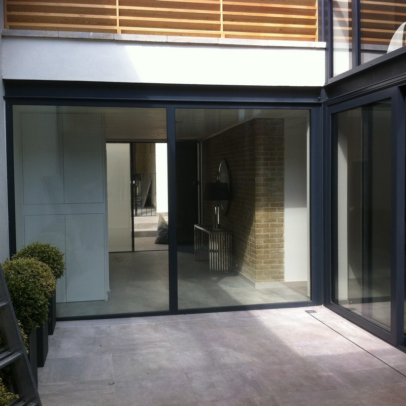 Floor-to-ceiling sliding doors opening to courtyard in Radlett