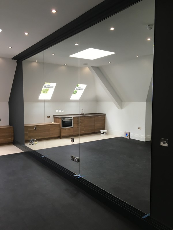 Frameless glass partition in loft conversion by Radlett glaziers