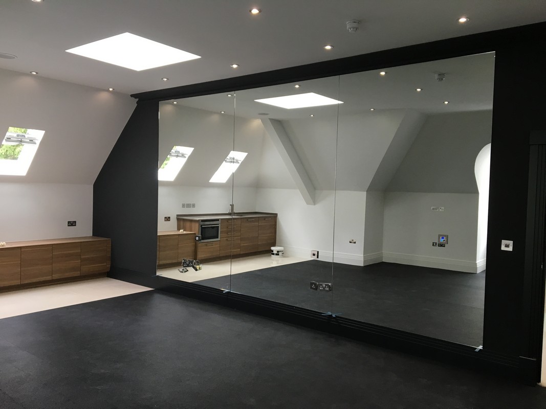 Frameless glass wall dividing loft conversion in Radlett